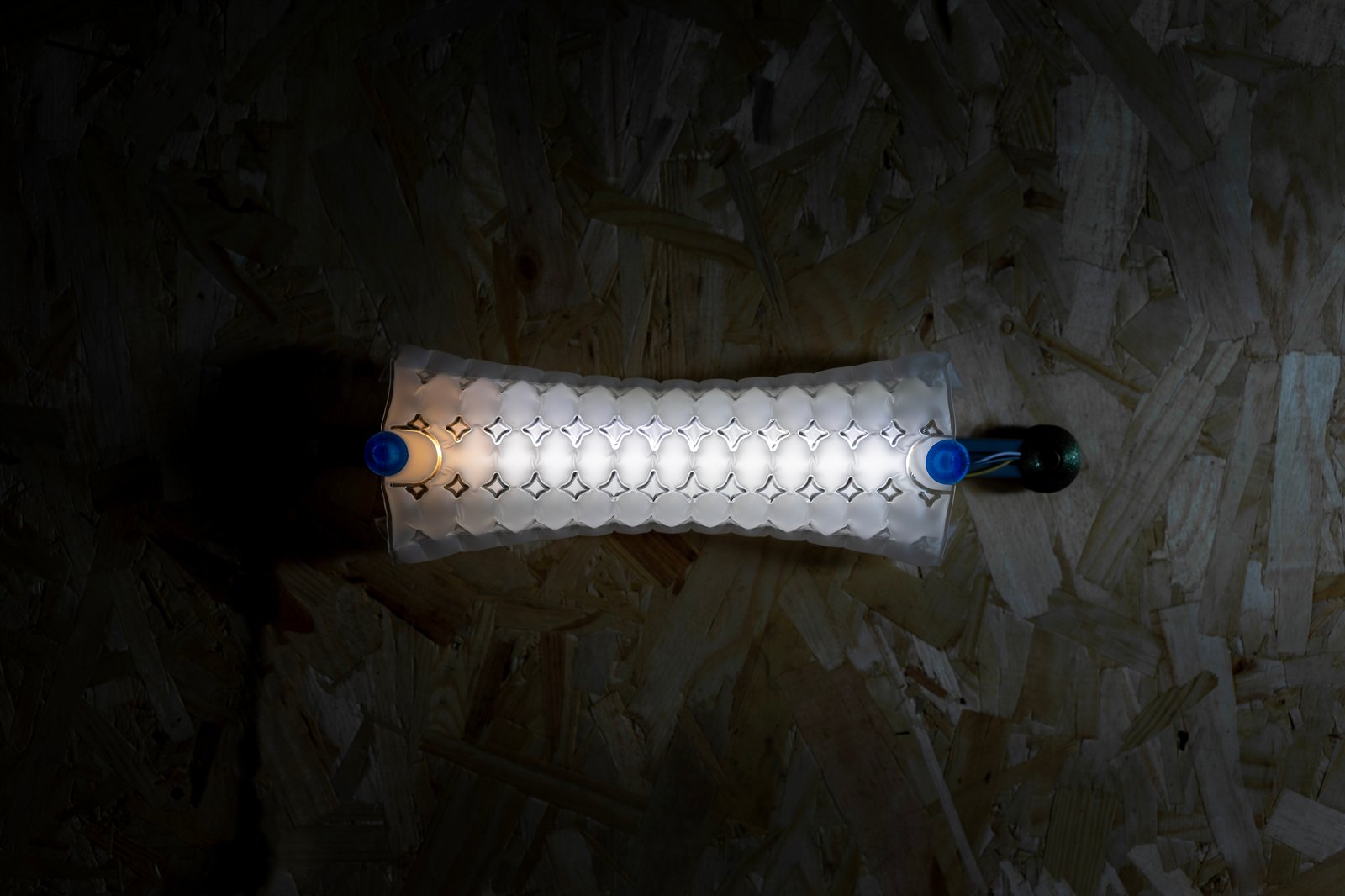 Air Forming Lamp glowing on an OSB wall